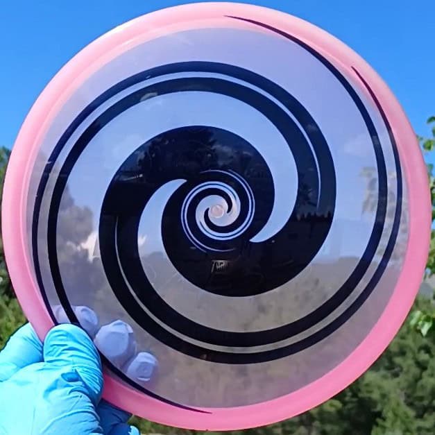 040102.03 Maestro Double Spiral disc golf midrange with custom geometric design. Pink disc with black spirals.