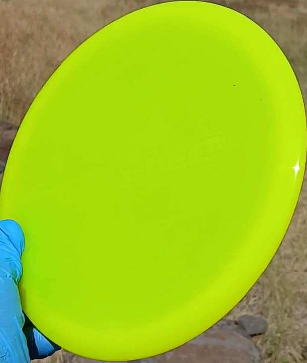 8801402.02 Lucid Justice yellow disc golf overstable midrange from Dynamic Discs. Wiped ghost stamp front tilt view