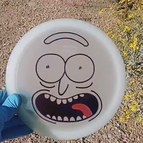 Discmania Active Premium Glow Rockstar with Rick and Morty design. Glow-in-the-dark fairway driver shown in a desert scenario in the daytime.